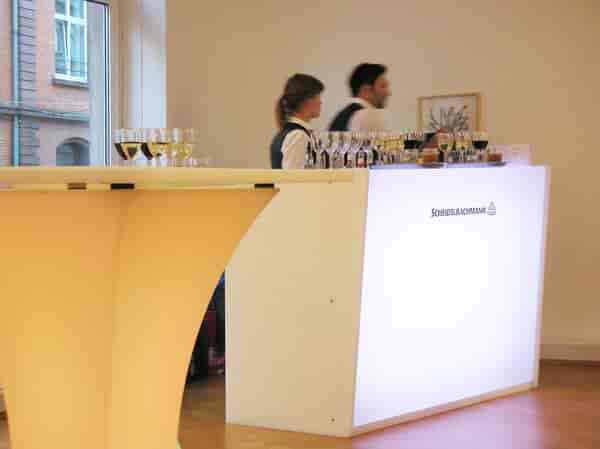Cocktail reception setup at Bernhard Knaus Fine Art with backlit bar for corporate event venue.