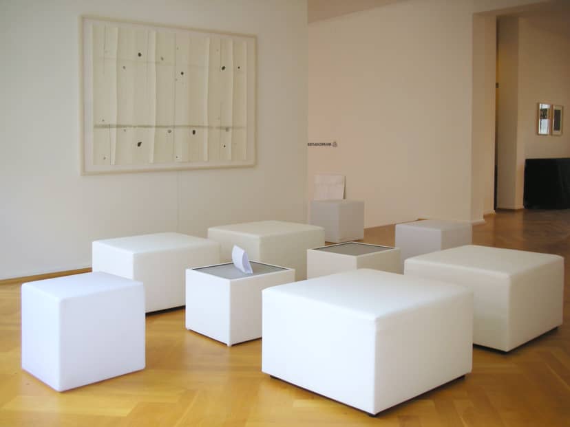 Minimalist gallery breakout area with modular seating for corporate networking events.
