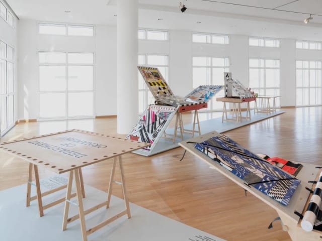 Minimalist gallery space for luxury event planning featuring bespoke interactive tabletop displays.