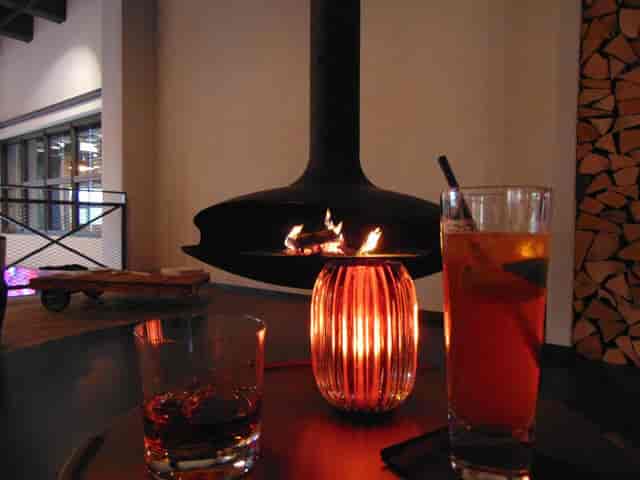 Vintage loft gallery with suspended fireplace for VIP networking and event hospitality.