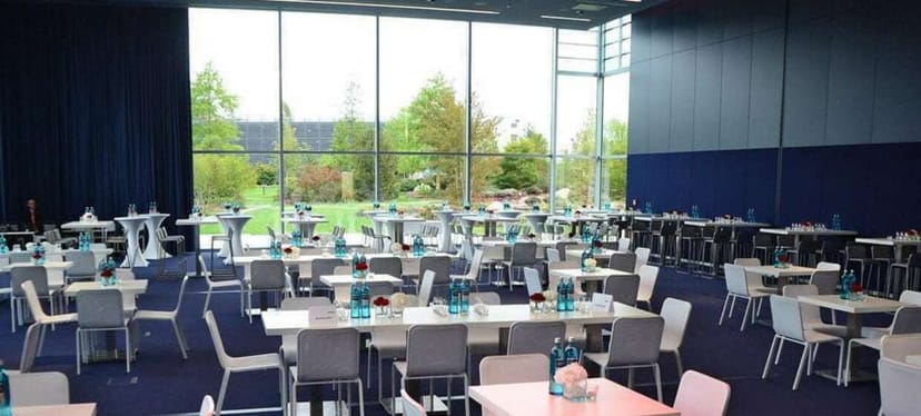 Halle 3 event space with floor-to-ceiling windows for corporate networking and banquet reception.