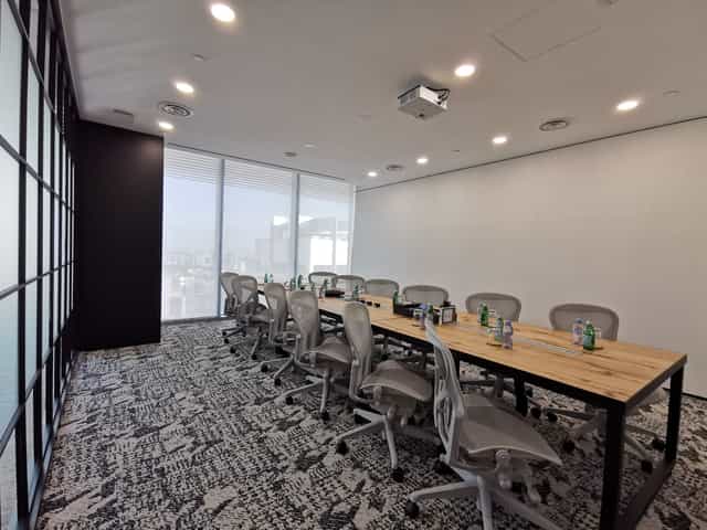 Modern boardroom with live-edge table and city views for executive meetings and corporate events.