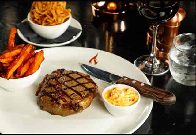Premium steakhouse entrée with red wine for executive VIP dinner and networking gala events.