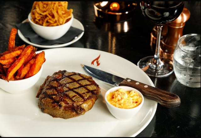 Premium steakhouse entrée with red wine for executive VIP dinner and networking gala events.