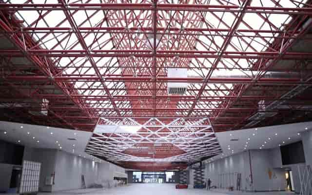 Rodos Hall at Istanbul Fuar Merkezi with red-truss ceiling for exhibitions and brand events.