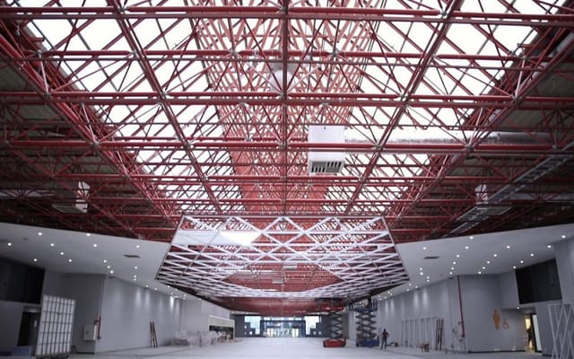 Rodos Hall at Istanbul Fuar Merkezi with red-truss ceiling for exhibitions and brand events.