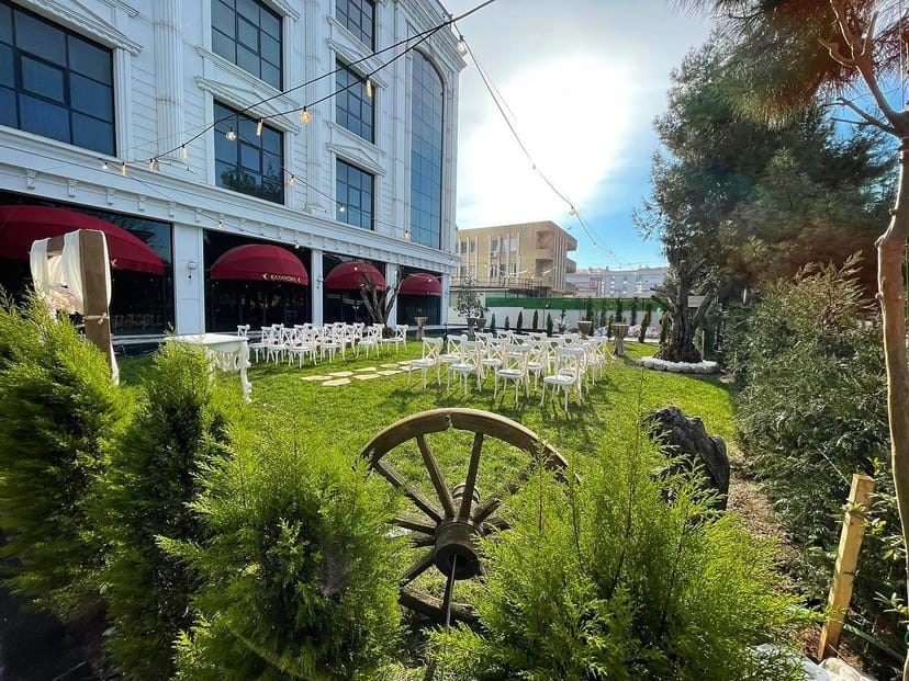 Zümrüt Bahçe garden wedding ceremony with rustic bistro lighting and banquet seating.