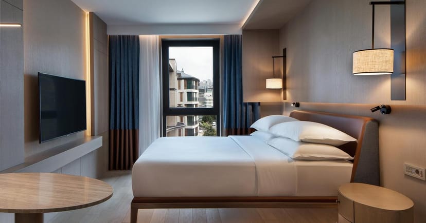 Modern Sheraton Istanbul City Center guest room with workspace for corporate business travel.
