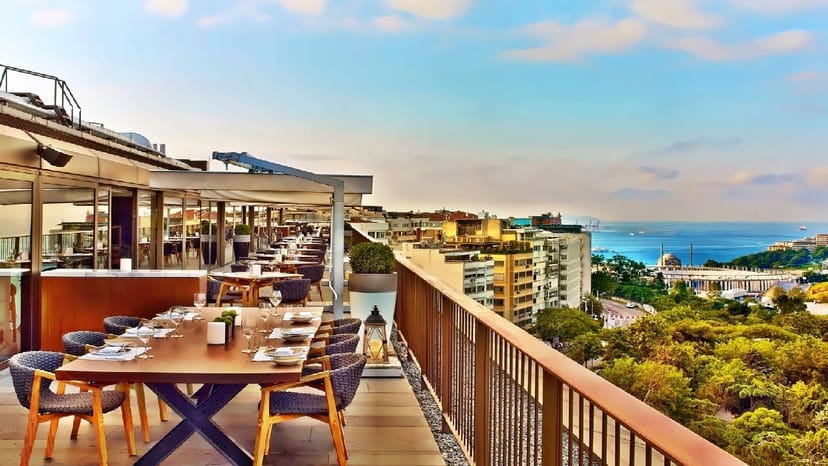 Rooftop corporate reception at The St. Regis Istanbul with panoramic city views and dining setup.