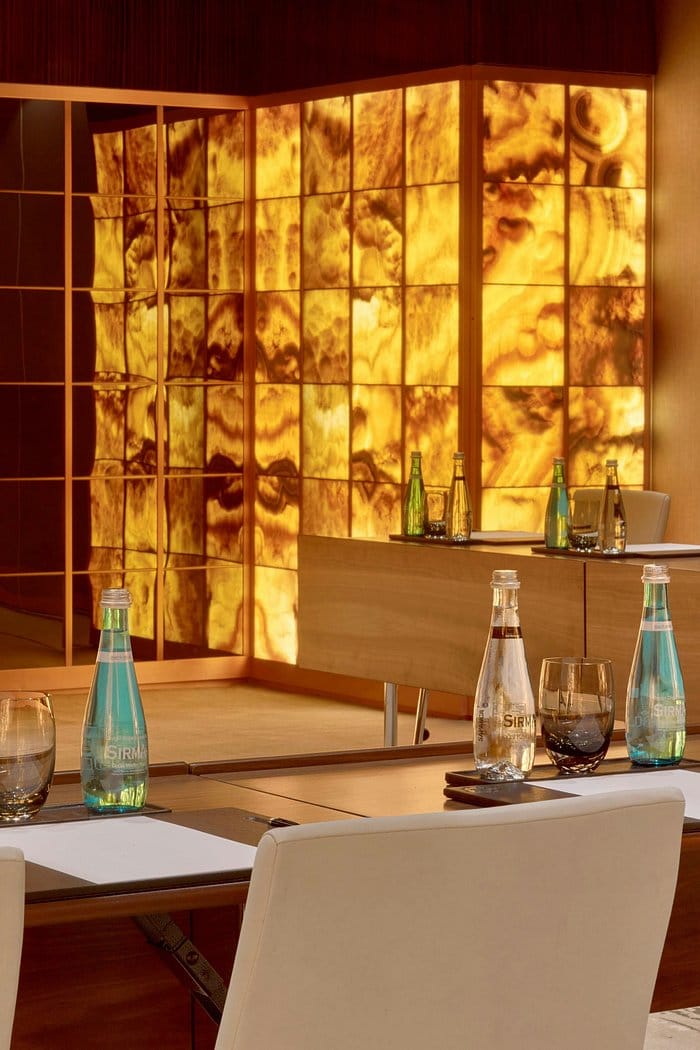 Astor Ballroom boardroom setup with backlit onyx wall for luxury corporate meetings and events.