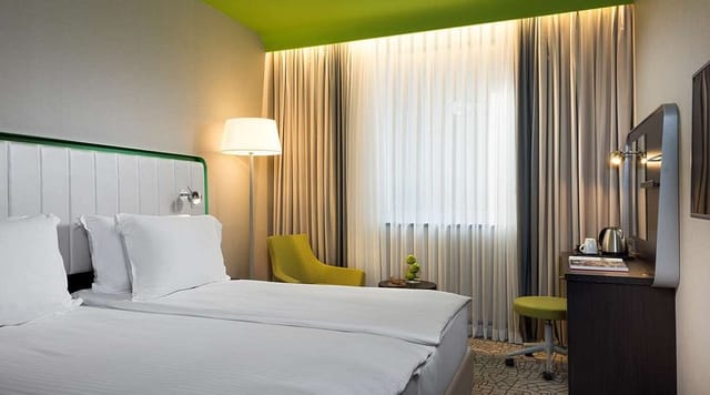 Contemporary Park Inn Istanbul Atasehir guest room with workspace for business travel events.