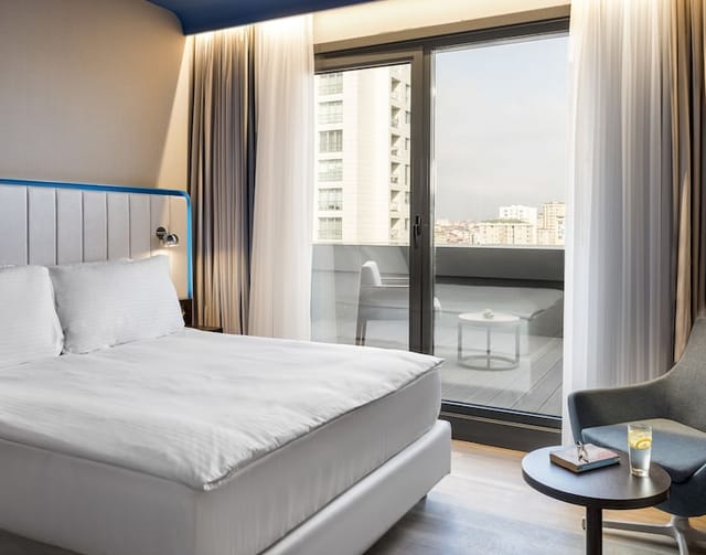 Modern hotel room with balcony at Park Inn by Radisson Istanbul Atasehir for corporate events.