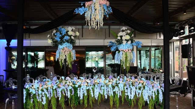 Luxury event head table with blue and white floral centerpieces for weddings and galas.