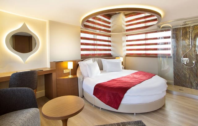 Circular bed and open shower in Veyron Hotel spa suite for romantic getaway or boutique stay.