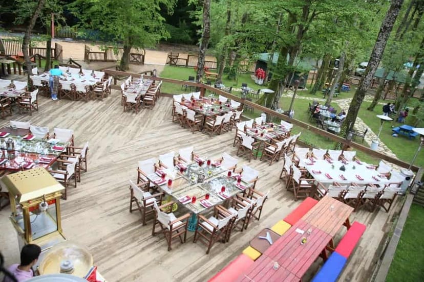 Henna and bachelorette party setup on a tiered deck in a rustic forest, ideal for event venues.