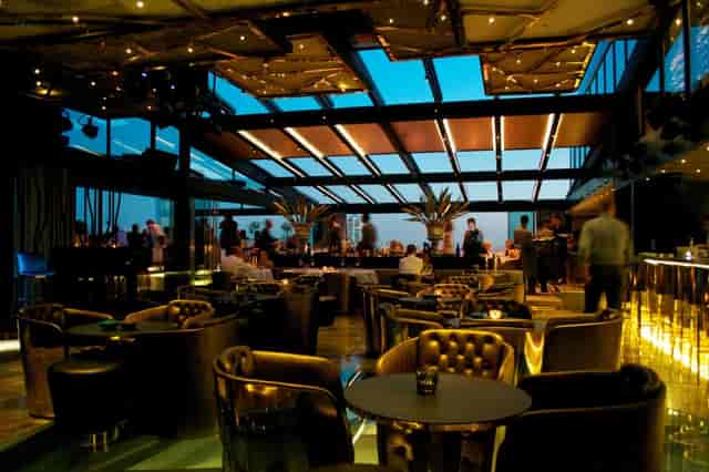 Retractable-roof rooftop lounge for upscale corporate networking and evening reception events.