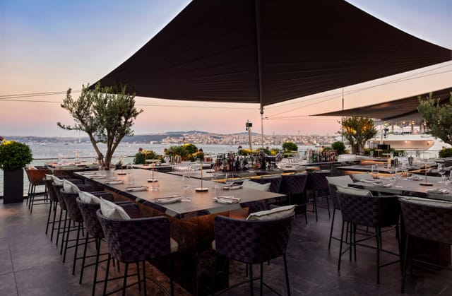 High-end waterfront event space with high-top tables for cocktail receptions and networking mixers.