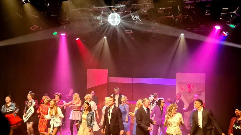 Corporate gala finale at Brentwood Theatre featuring dramatic lighting and disco ball event decor.