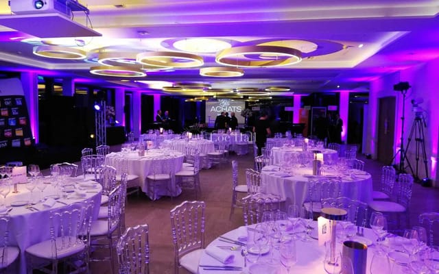 Banquet-style function room at Pavillon Royal with purple uplighting for evening gala events.