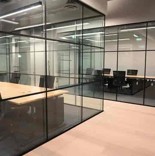 Modern glass-partitioned meeting room for confidential corporate sub-committee breakout sessions.