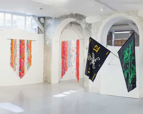 Industrial-chic L'Atelier gallery with stone arches for art pop-ups and brand activations.