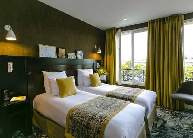 Modern twin guest room at Hôtel de Neuville, ideal for corporate travel and business meetings.