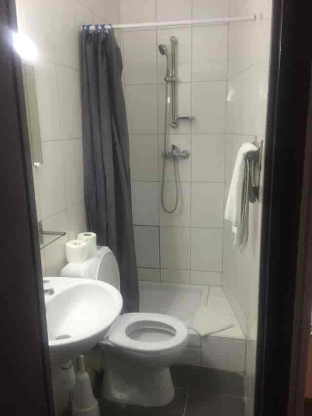 Dated bathroom in Hotel Chevallier; cramped budget hotel room for event venue planning.