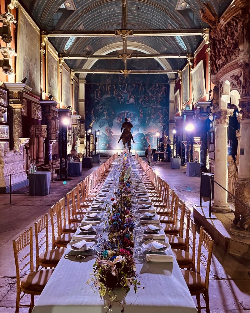Gala dinner in historic Chapelle des Petits-Augustins with long-table banquet seating.