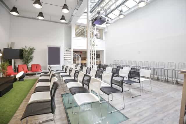 Industrial-chic meeting room with theater seating for professional presentations and workshops.