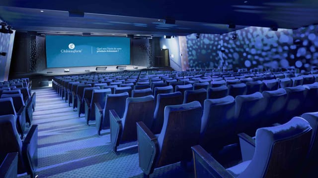 Theater-style corporate meeting room with tiered seating for keynote presentations and events.