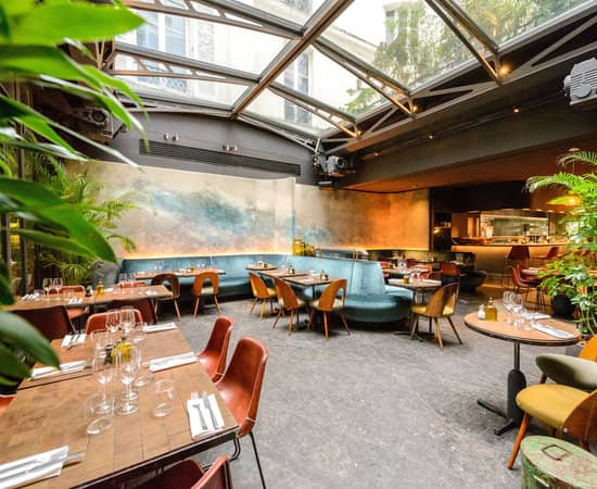 Sunlit hotel atrium bar, perfect for sophisticated corporate dinners and networking events.