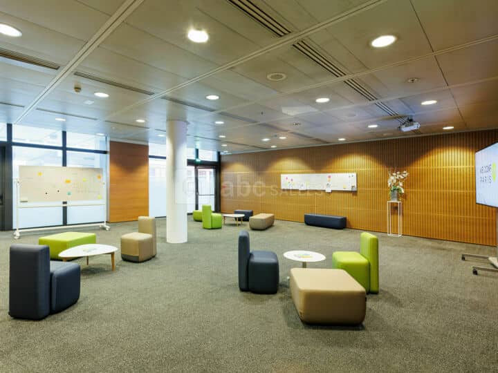 Modern breakout room with modular seating for collaborative corporate workshops and networking.