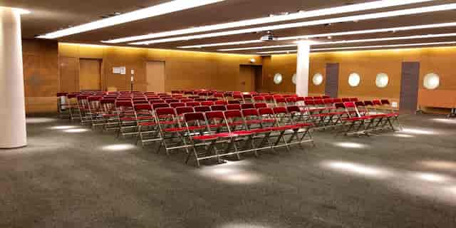 Theater-style meeting room with red chairs at Cœur Défense conference center.