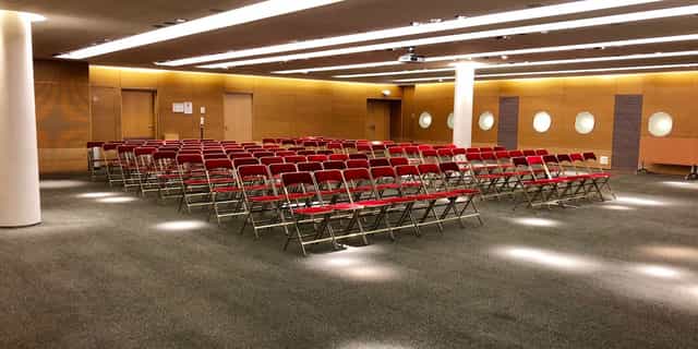 Theater-style meeting room with red chairs at Cœur Défense conference center.