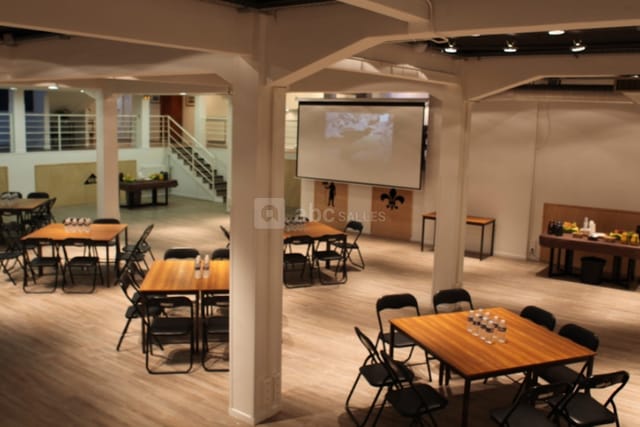 Industrial-chic Espace Batignolles venue with square tables for workshop and conference events.