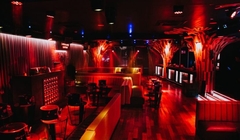 Cova Club Paris lounge with red ambient lighting for exclusive nightlife events and social parties.