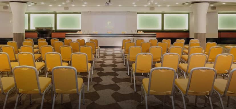 Carmagnola Room boardroom setup with yellow chairs for corporate training and professional seminars.