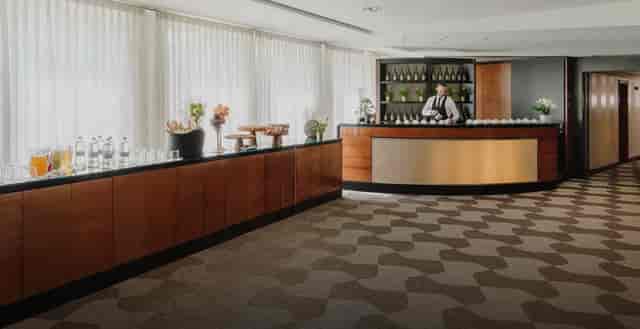 Carmagnola Room with staffed bar and modular stations for corporate networking events.