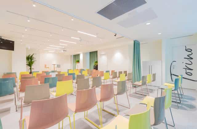 Modern Madrid conference room with colorful theater seating for workshops and creative meetings.