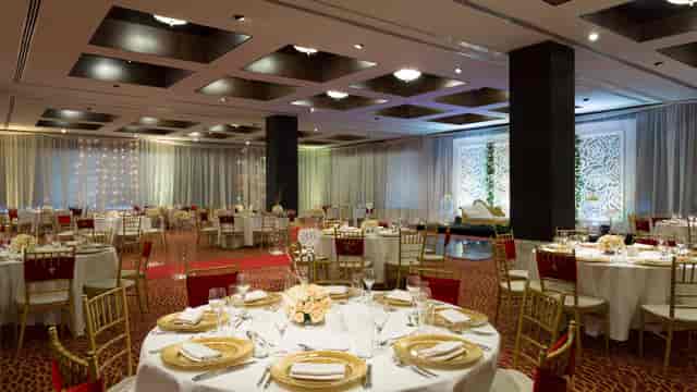 Banquet-style wedding gala event space with red and gold decor at Hyatt Regency Dar es Salaam.