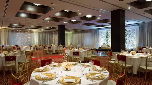 Banquet-style wedding gala event space with red and gold decor at Hyatt Regency Dar es Salaam.