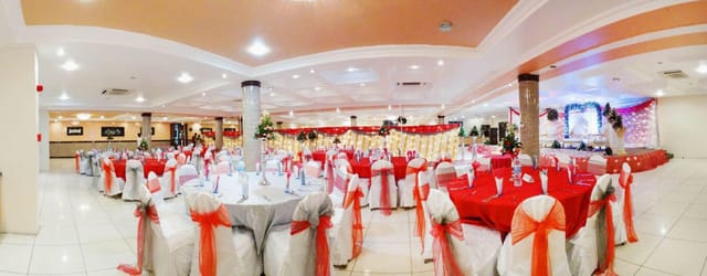 Banquet setup at Mayfair Hotel with red and white linens and venue pillars for event planning.