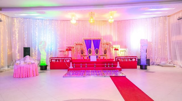Wedding reception dining area at Kebby's Hotel with elegant stage-focused event décor.