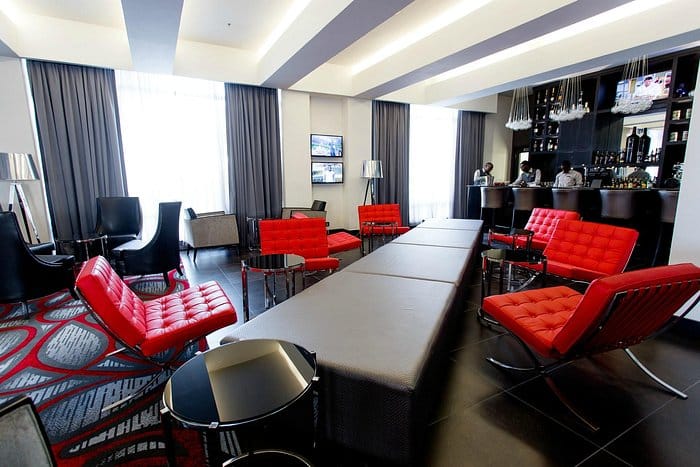 ONOMO Hotel rooftop lounge with vibrant red chairs for networking events and social mixers.