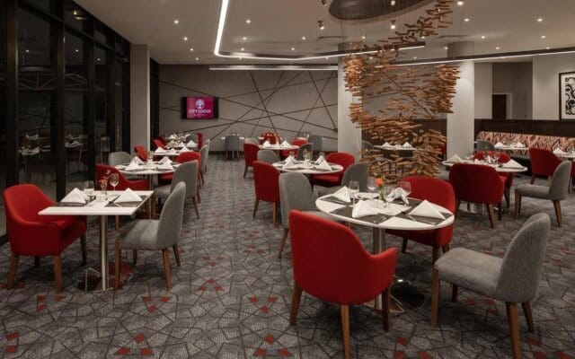 Modern City Lodge meeting room featuring red and grey decor for corporate events or private dinners.