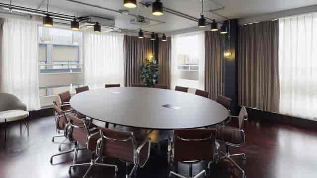Modern boardroom with oval table for executive meetings and strategy sessions.