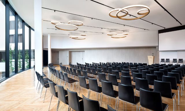 Faggio C Room theater setup, modern wood flooring: corporate event and panel discussion venue.