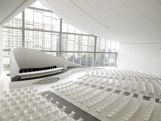 Heydar Aliyev Center exhibition hall with curved stage for corporate events and conferences.