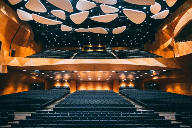 Modern auditorium with tiered seating, ideal for corporate keynote presentations and conferences.