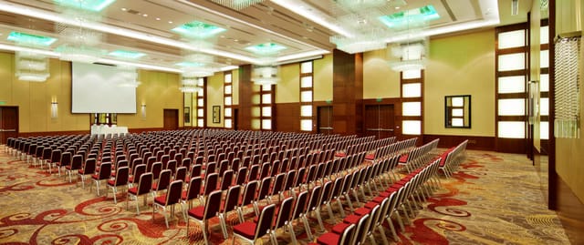 Modern hotel banquet hall set for theater-style conference and corporate event.